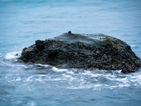 Sea waves impact rock on the beachの写真素材