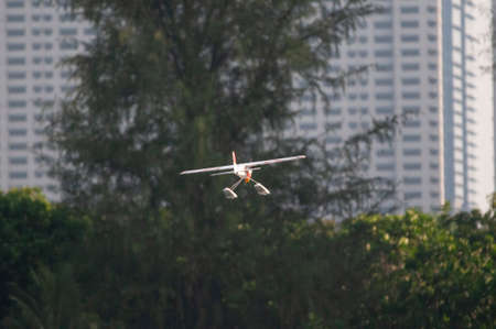 Radio controlled float plane flying toward residential building.のeditorial素材