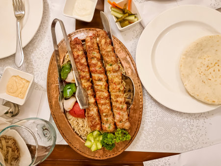Arabic and Lebanese bbq cuisine meat appetizer kibbeh or kabab on a plate with pita bread and rice. Horizontal view from aboveの写真素材