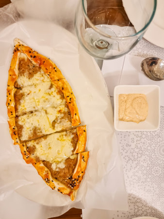 Arabic and Lebanese cuisine meat and cheese pide on a plate with ranch sauce. Horizontal view from aboveの写真素材
