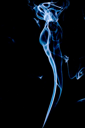 bluish-white smoke rising with black backgroundの写真素材