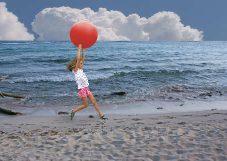 Girl Running with ball on beachの写真素材