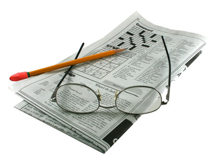 newspaper puzzles, eyeglasses and pencil on an isolated backgroundの写真素材