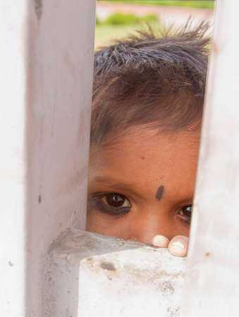 little girl looking through a gate - Delhi, Indiaのeditorial素材