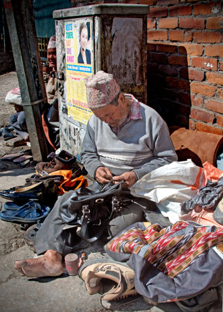 A Nepalese shoe repairman on a strret of Kathmanduのeditorial素材