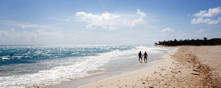 a couple wading on the beach in Mexicoの写真素材