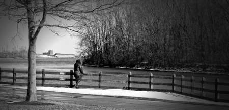 Lonely woman at river in winterの写真素材
