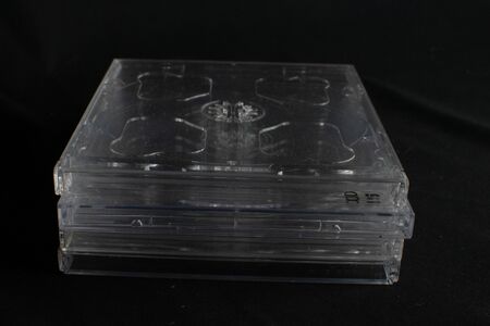 Stack of clear retro CD cases with no Compact Discs against a black backgroundの写真素材