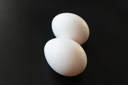 Raw chicken egg on a black backgroundの写真素材