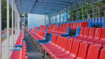 Colorful plastic seats at a sports stadium, in a city park.