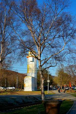 Lighthouse in the city park against the blue sky on a sunny dayの写真素材