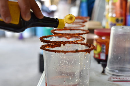 Preparing the glasses for some micheladas with salt and hot saucesの写真素材