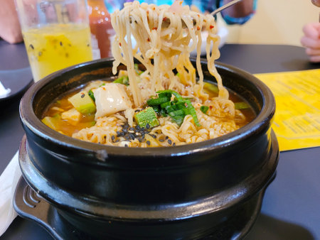 View of a japanese ramen, served in a black dish over wooden tableの写真素材