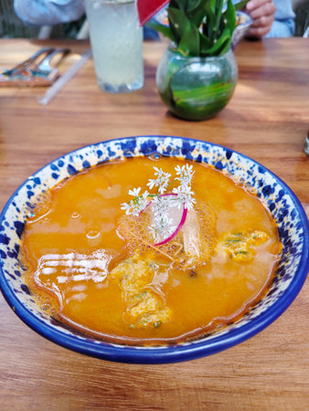 Vertical view of Hearty menudo soup, a Mexican culinary staple, garnished with fresh herbsの写真素材