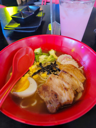 Vertical View of Delicious ramen with tender pork, boiled egg, and avocado in a rich brothの写真素材