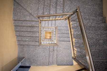 Top view of a spiral staircase with metal railing inside the Zapopan Art Museum, Mexico, showing geometric symmetryの写真素材