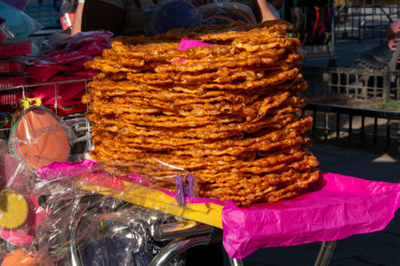 Guadalajara, Mexico - February 2 2025: Close-up of a large stack of traditional caramelized peanut wafers displayed at a street stall in Guadalajara's historic centerの写真素材