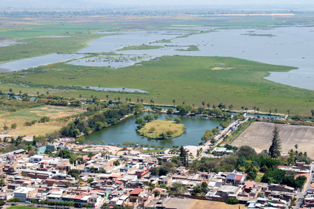 Wide landscape of Jamay, Jalisco, featuring Xamain Island, the lake, and lush green surroundings under clear skiesの写真素材