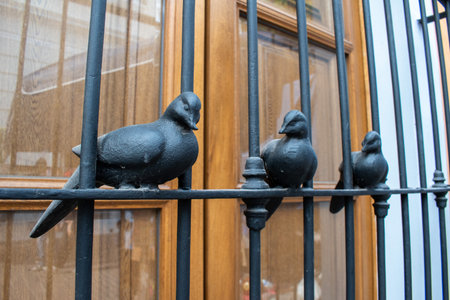 Close-up of three metal bird sculptures attached to window bars in Tlaquepaque, Jalisco, Mexicoの写真素材