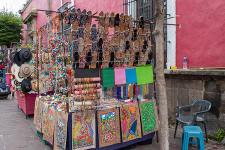 Tlaquepaque, Mexico - October 5 2025: A vibrant outdoor market stall in Tlaquepaque, featuring traditional artisan crafts, including colorful sandals, hats, and folk artのeditorial素材