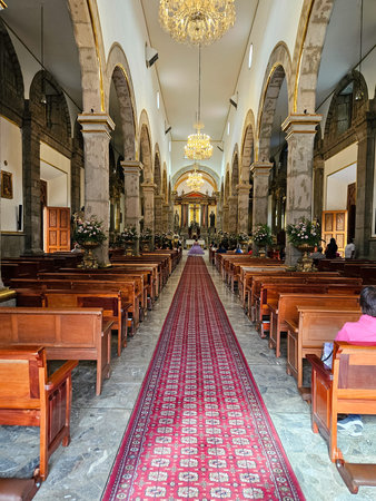 Tlaquepaque, Mexico - July 13 2024: Inside Saint Peter the Apostle Parish in Tlaquepaque, Jalisco. Features nave, wooden pews, red aisle carpet, and chandeliersのeditorial素材