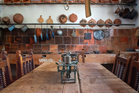 Rustic Mexican kitchen inside a historic hacienda with clay cookware, hanging utensils and scaleのeditorial素材