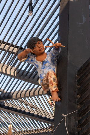 Tlaquepaque, Mexico - April 19 2025: Artistic sculpture of cheerful child with slingshot displayed on iron beam at Andador Independenciaのeditorial素材