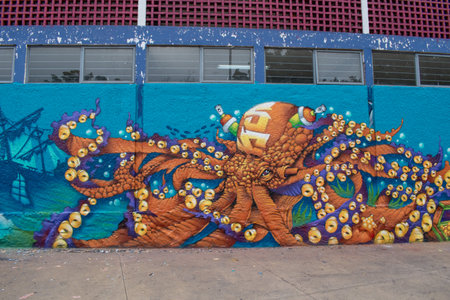 Guadalajara, Mexico - May 29 2025: Vibrant street art of orange octopus with many eyes painted on blue wall at public park on Avenida Normalistas in Guadalajaraのeditorial素材