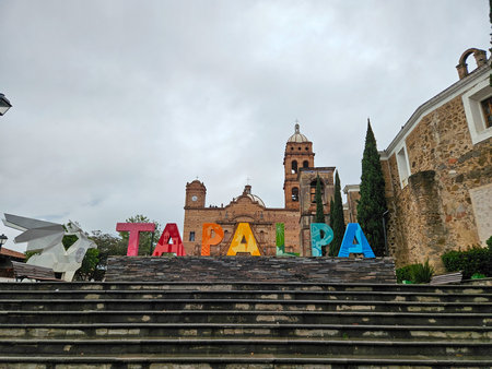 Tapalpa, Mexico - July 15 2024: Vibrant letters spelling Tapalpa, a Pueblo Magico in Jalisco, prominently displayed with the church under an overcast sky.のeditorial素材