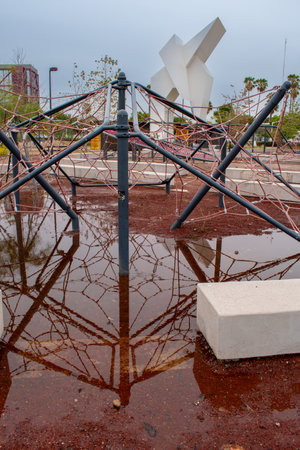 Guadalajara, Mexico - May 29 2025: Geometric climbing structure with puddle reflection in recreational park near monument at Glorieta de la Normal, Guadalajara, Jaliscoのeditorial素材