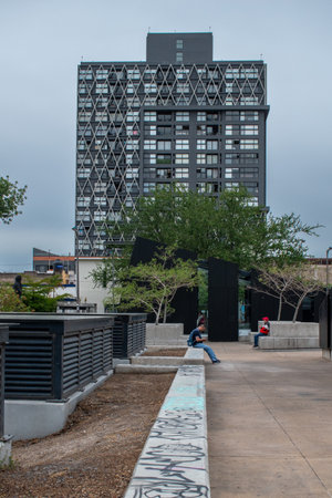 Guadalajara, Mexico - May 29 2025: Urban public space with benches, trees, graffiti and a geometric residential building near Glorieta de la Normal, Guadalajara, Jaliscoのeditorial素材