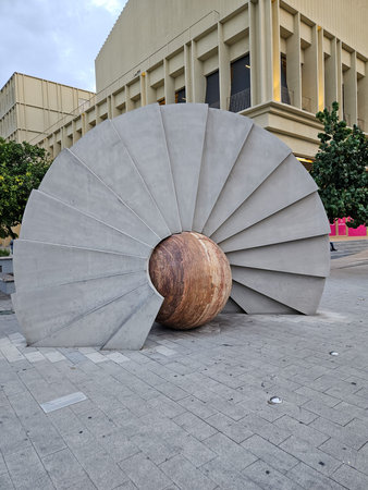 Zapopan, Mexico - July 13 2024: Full view of the Peacock abstract sculpture in Zapopan, Jalisco. The unique artwork combines a large gray concrete fan shape with a rustic brown sphereのeditorial素材