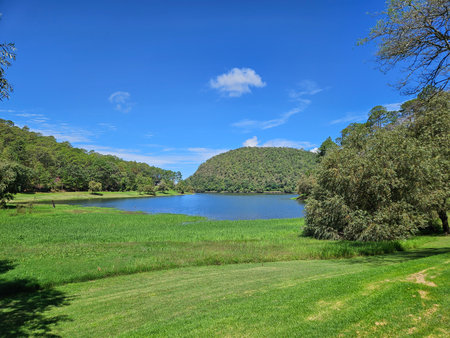 Tranquil panoramic view of San Juanacatlan Lagoon in Jalisco, Mexico, with lush green landscape and clear blue sky on a bright sunny day.の写真素材