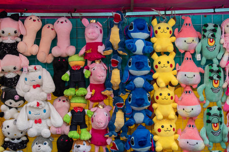 Tlaquepaque, Mexico - June 28 2025: Vibrant display of diverse plush toys, including popular cartoon characters, presented as prizes at a lively fair game stall in Tlaquepaqueのeditorial素材