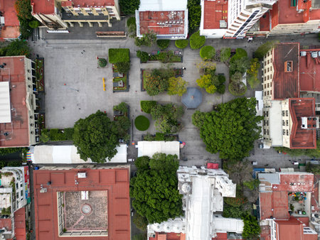 Top-down drone view of Chilpancingo's Civic Square First Congress of Anahuac, Mexico. Features green areas, walkways, a central gazebo, and historical buildings with red roofsの写真素材