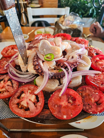 Colorful Mexican seafood platter with octopus, shrimp, scallops, red onions, tomatoes, jalapeno. Fresh, authentic, on rustic wooden boardの写真素材