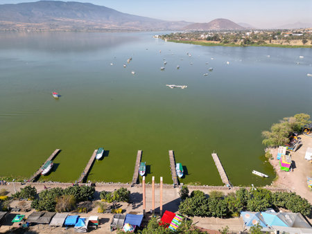 High altitude aerial perspective of boat docks on the shore of Cajititlan Jalisco Mexico over green lake watersの写真素材