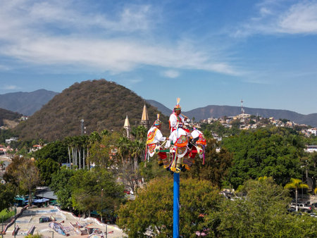 Chapala, Mexico - December 13 2025: Papantla Pole Flyers perform ancient ritual in Chapala. Colorful performers descend from tall pole, cultural spectacleのeditorial素材