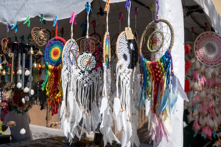 Zapopan, Mexico - February 21 2026: A close-up view of numerous colorful handmade dreamcatchers and other traditional crafts hanging at an outdoor artisan market stall. Intricate designs, feathers, and beads are visibleのeditorial素材