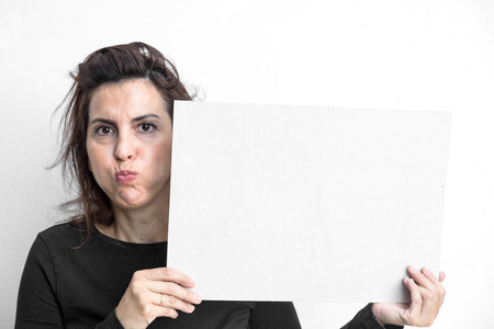 Beautiful brunette woman doing all kinds of gestures and emotions with blackboard isolated on white backgroundの写真素材