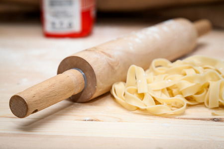 Fettuccini pasta with parsley and hot peppers on wooden tableの写真素材