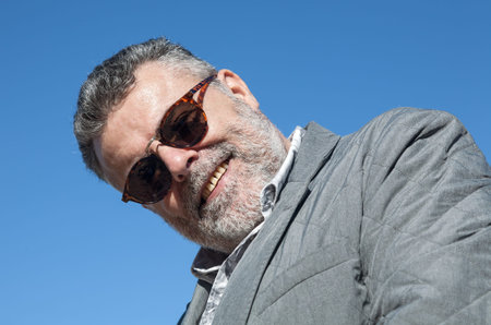 Portrait of attractive man with beard blue sky backgroundの写真素材