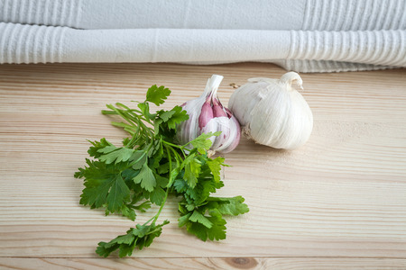 Composition of purple garlic with parsley on wooden boardの写真素材