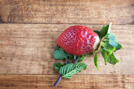 Delicious strawberries in white bowl on wooden tableの写真素材