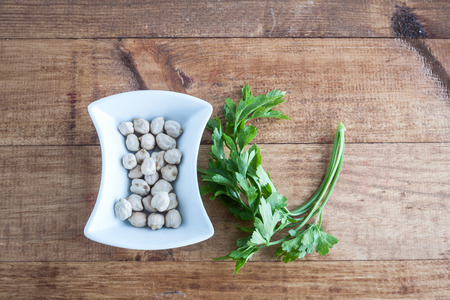 Sack with chickpeas and parsley on wooden tableの写真素材