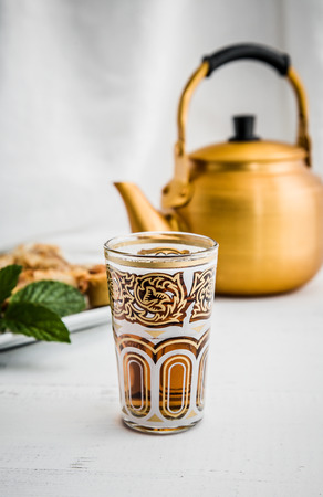 Arabian golden teapot on white wooden tableの写真素材