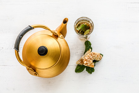 Arabian golden teapot on white wooden tableの写真素材