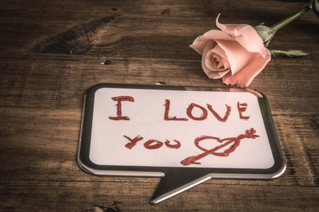 Blackboard on white wooden table shaped cloud with place for writing textsの写真素材