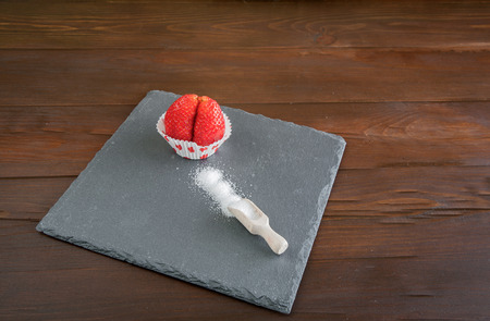 Delicious strawberries in white bowl on wooden tableの写真素材