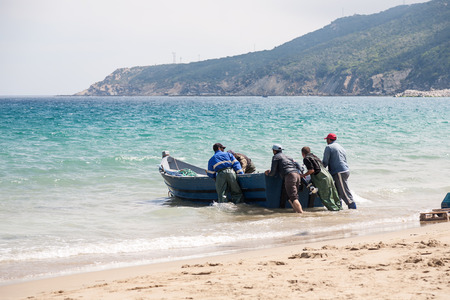 MAY 2 2015TANGIER MOROCCO: Unidentified men pull a fishing boat to the beach.のeditorial素材
